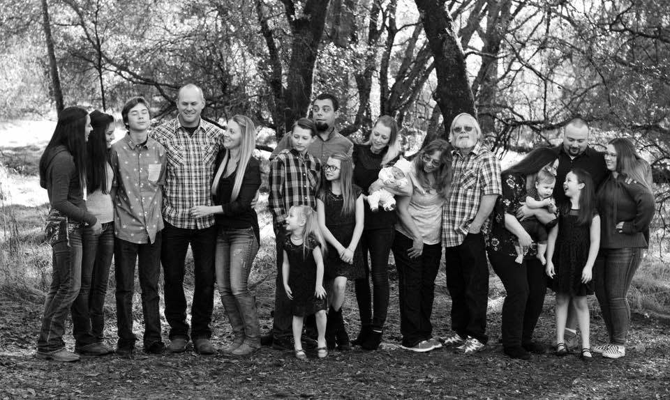 Multi-generation family portrait beneath mature trees